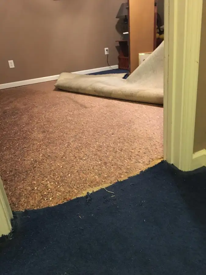 Carpet pad removal revealing water damage during Water Mitigation Services in Fond du Lac